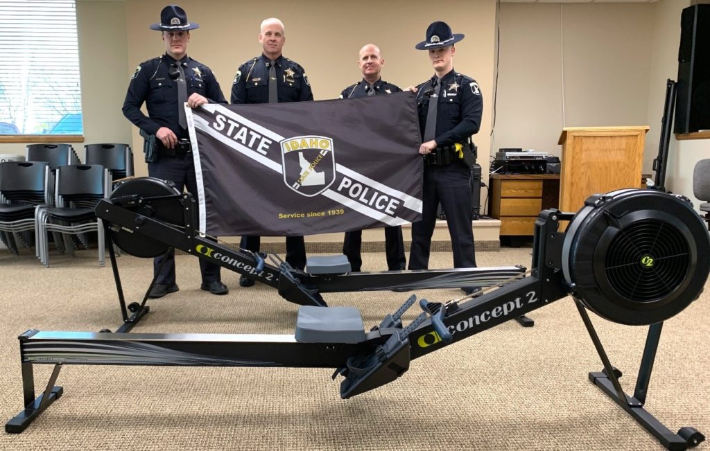 Police officers standing beside rowing machine donated by Melaleuca