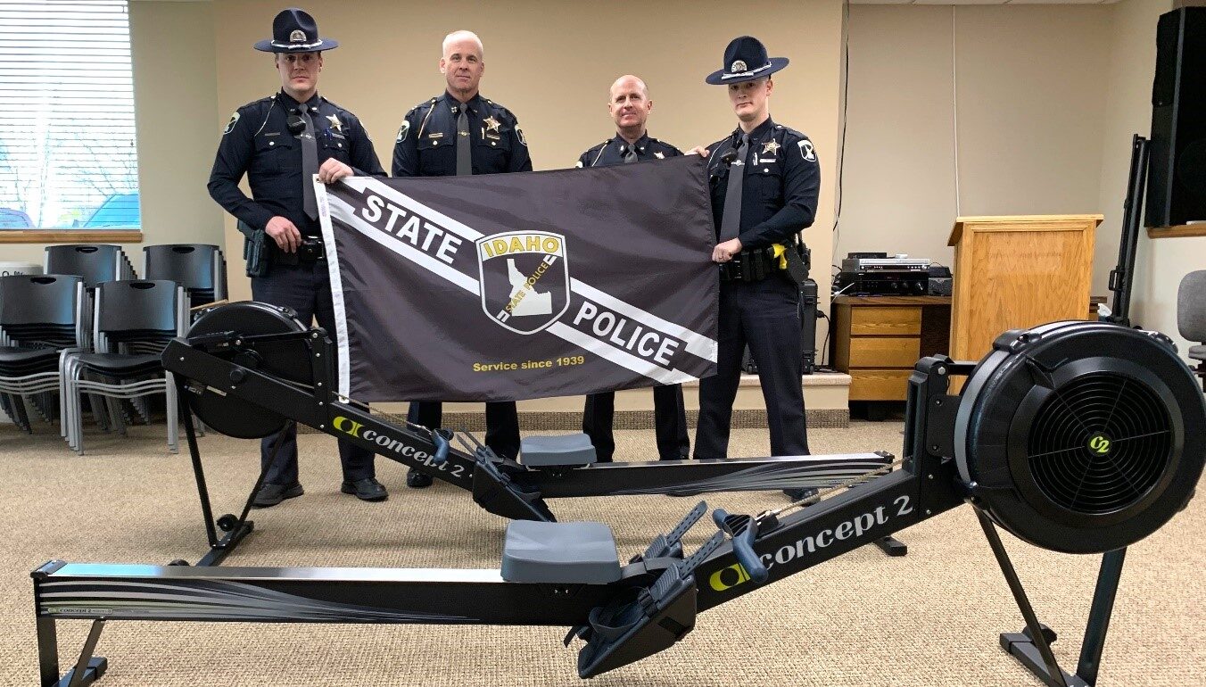 Police officers standing beside rowing machine donated by Melaleuca
