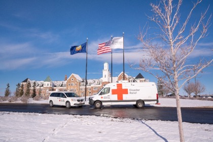two Red Cross vehicles in front of the Melaleuca Headquarters buildings.