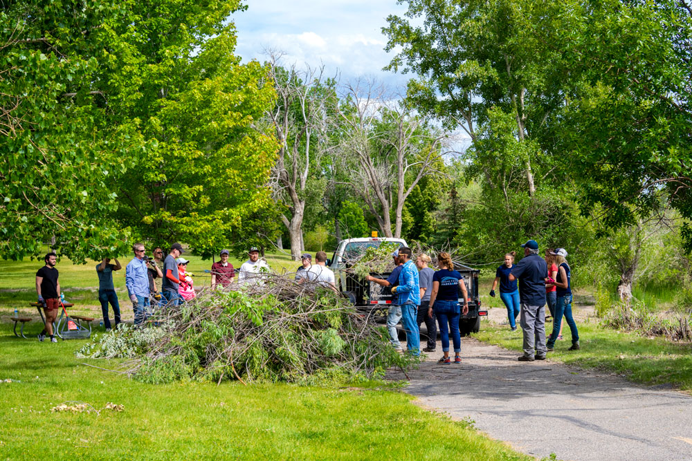 Melaleuca employees loading debris unto a truck from local river walk service project