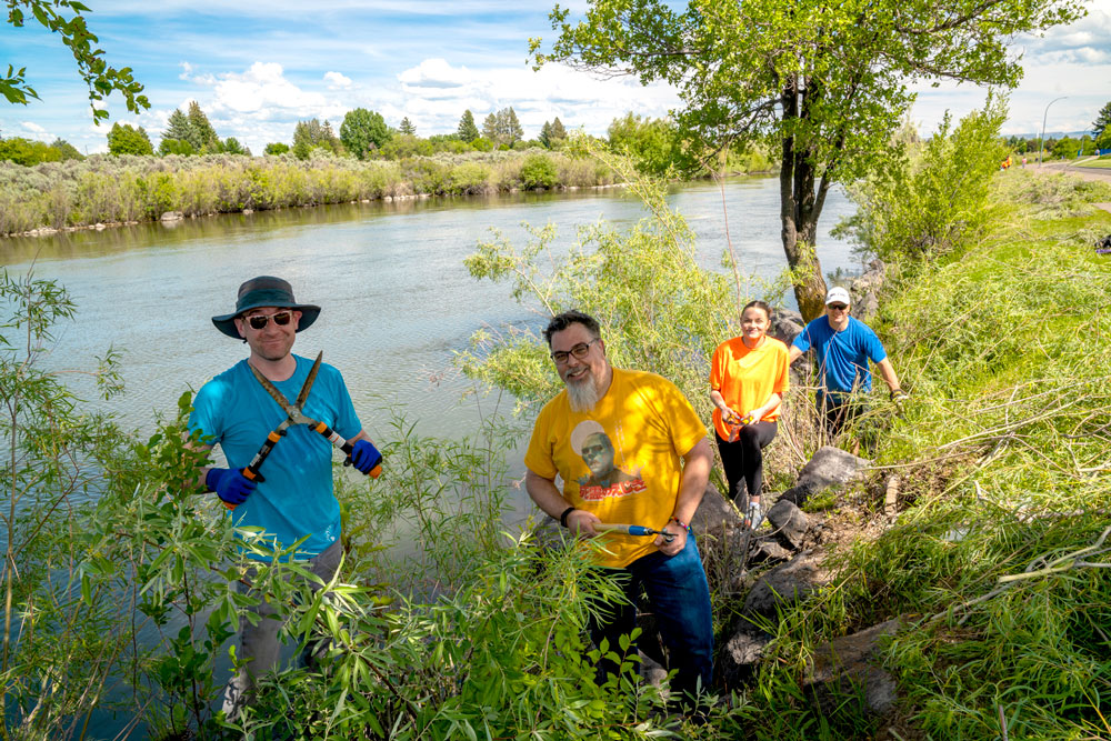 Melaleuca employees clearing out weeds along local river walk