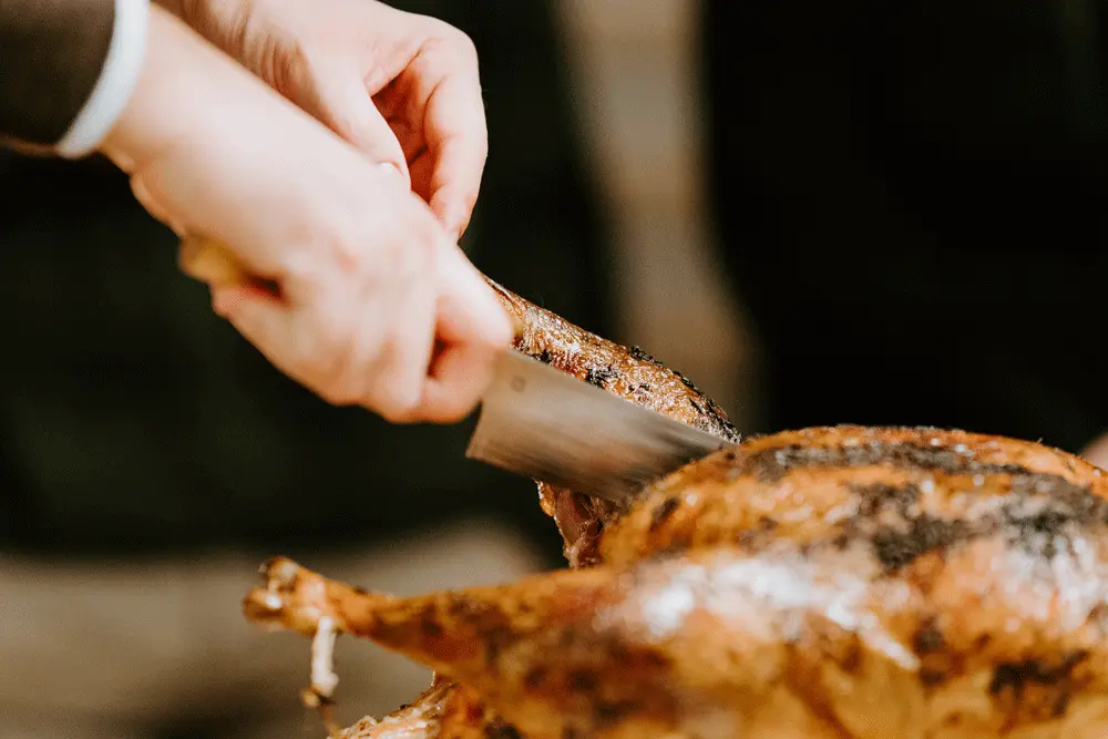 A person cutting into a turkey