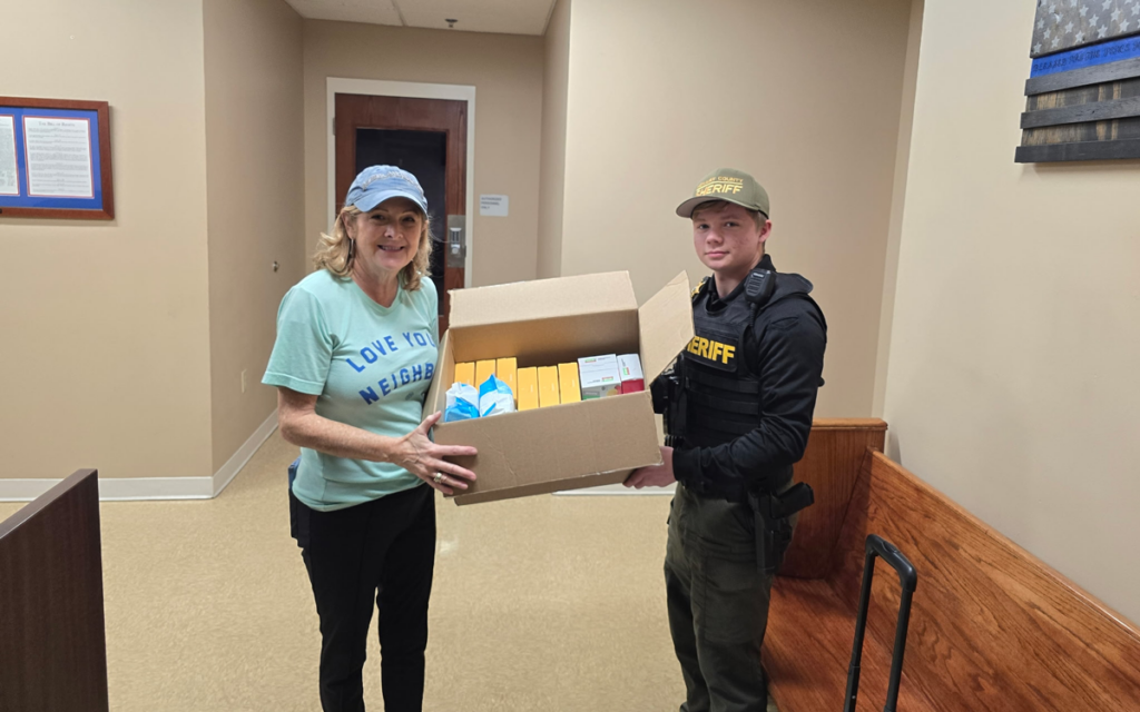 Melaleuca representative giving a box of Melaleuca products to a McNairy County Sheriff’s Office deputy.